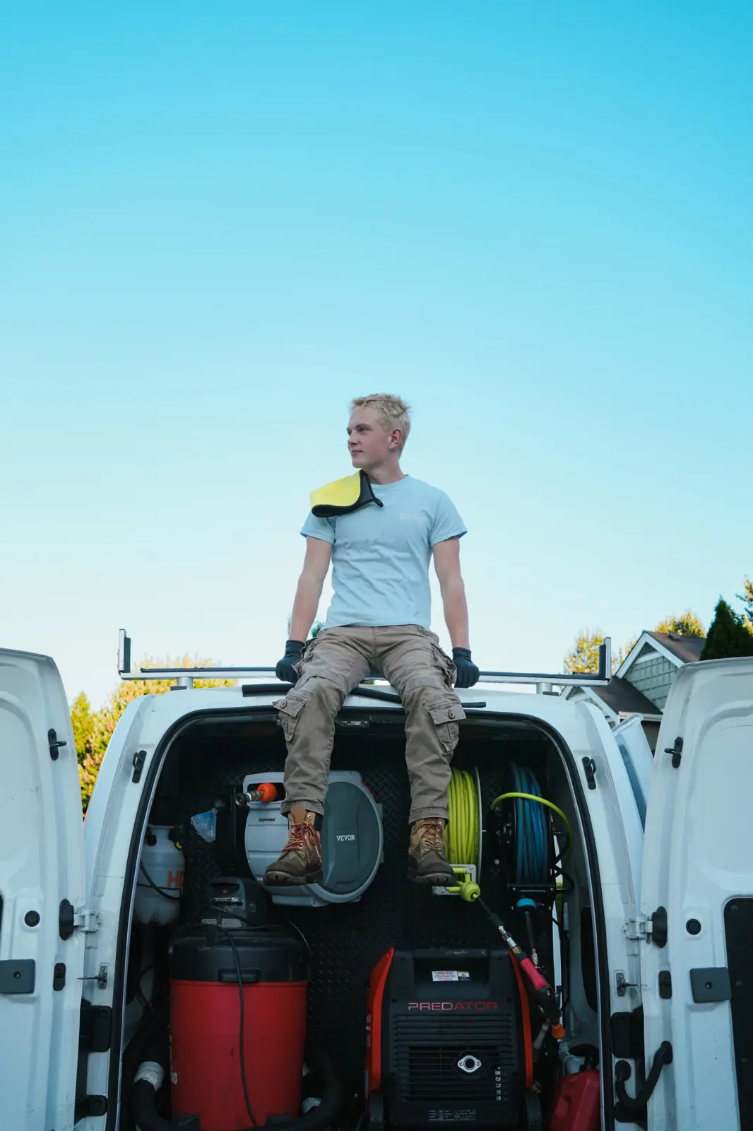 Daniel Christianson, owner of Tidy Touch, sitting on the back of the detailing van